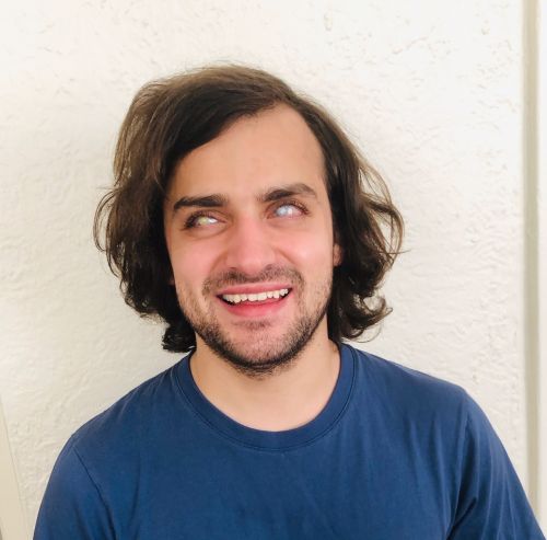 A headshot image of Carley smiling, wearing a blue t-shirt.