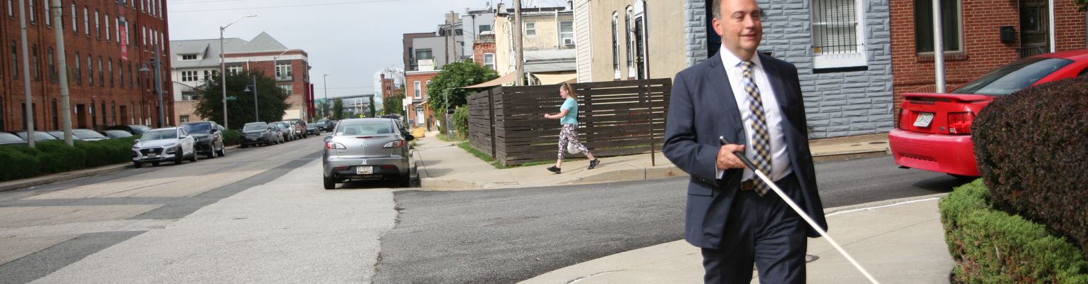 President Riccobono walks outside at a corner of an intersection