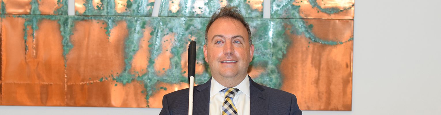 President Riccobono sits in front of a tactile painting