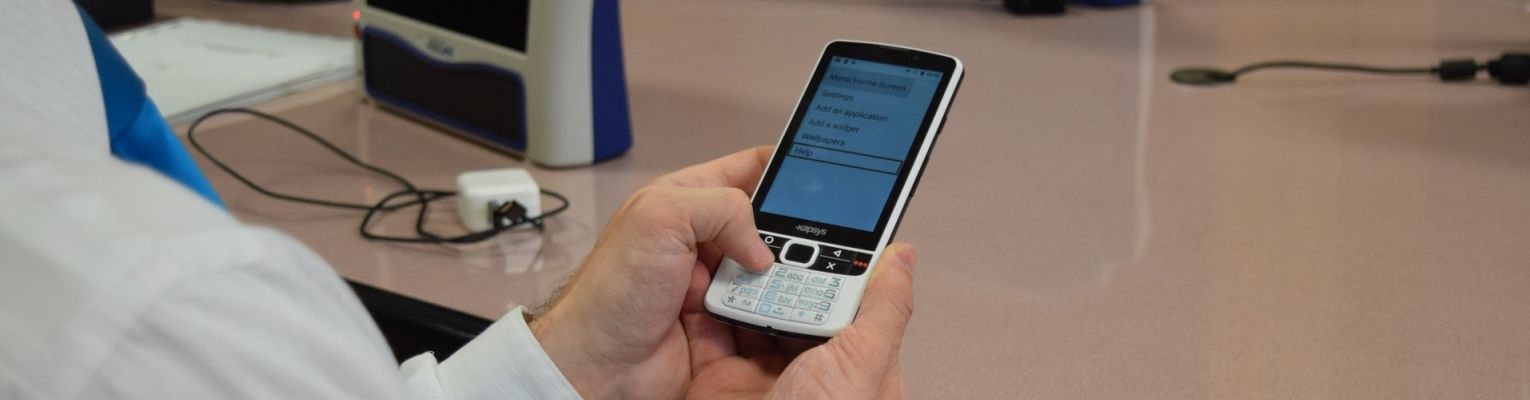A close-up shot of a man holding the SmartVision2 with both hands.