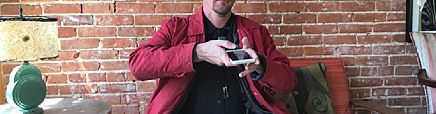 Joel uses the KNFB Reader app in a coffee shop to read the menu.